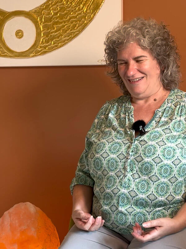 Carola Harter Channelmedium sitzt lächeln in stimmungsvollem Ambiente und channelt Engel